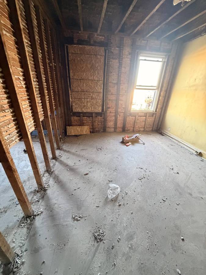 Room stripped to studs with sunlight through window